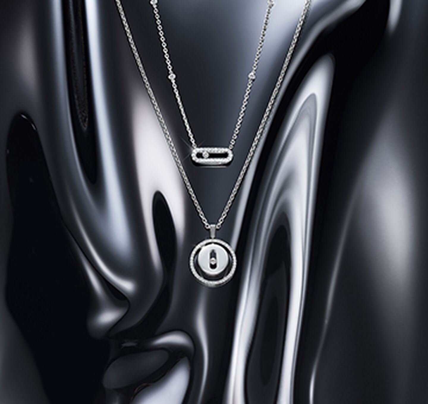 Messika white gold and diamond necklaces on a dark background.